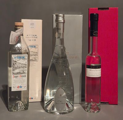 three bottles of alcohol and a box of wine on a table