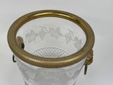 a glass vase with a gold handle on a white background