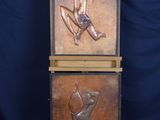 two bronze sculptures of a man and a woman on a pedestal