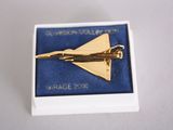 a gold airplane broocht in a blue box