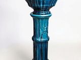 un vase en verre bleu orné d'un motif décoratif à la base