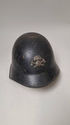 an old helmet is sitting on a table with a white background