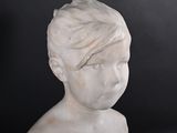 marble bust of a young boy with short hair on a black background
