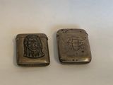 deux briquets en argent sur lesquels figurent l'image d'un homme et d'une femme