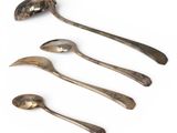 four spoons and a spoon rest on a white surface