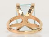 a close up of a gold ring with a blue topaz stone