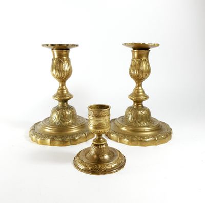 three brass candlesticks on a white background with a white background