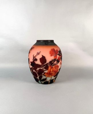 un vase orné d'un motif floral sur une surface blanche