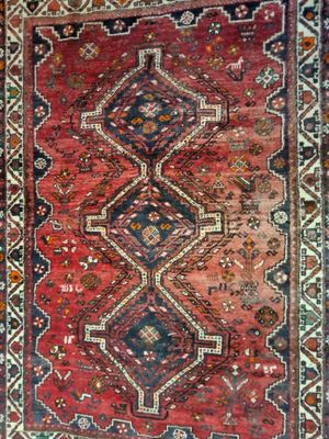 un vieux tapis persan orné d'un motif rouge et bleu