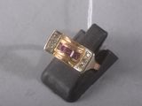 an image of a gold ring with a pink stone