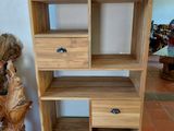 a wooden shelf with drawers on it in a room