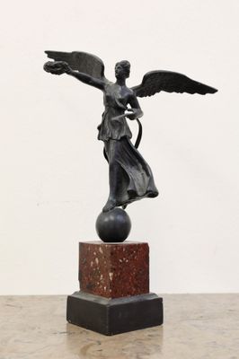 statue d'un ange tenant un oiseau, posée sur un socle en marbre