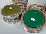 three silver containers with green lids on a white table