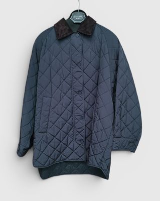a close up of a jacket hanging on a hanger on a wall