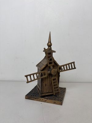 un petit bâtiment en bois surmonté d'un moulin à vent
