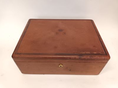 une vieille boîte en bois avec un couvercle et une poignée, posée sur une surface blanche