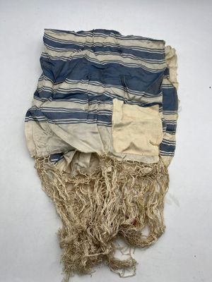 a close up of a blue and white striped towel on a white surface