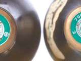 two brown vases that have green labels on them