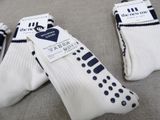 three pairs of white socks with blue dots on them sitting on a table