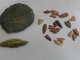 un caillou, une feuille et quelques autres objets posés sur une table