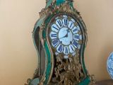 une horloge posée sur une étagère à côté d'une assiette