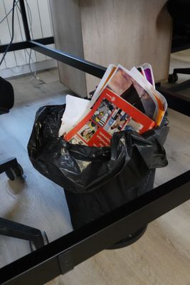 a black trash bag sitting on the floor next to a chair