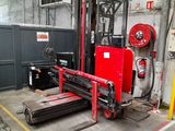 a red forklift in a warehouse with other equipment