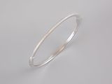 a close up of a silver bang bracelet on a white background