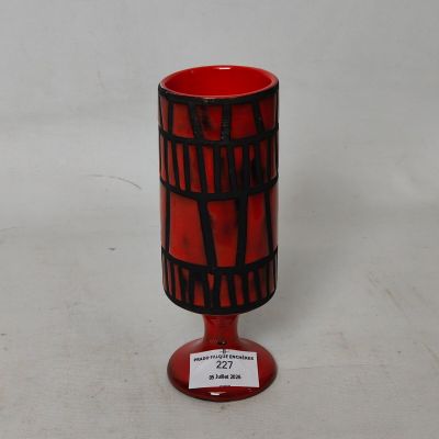 un vase rouge orné d'un motif en noir et blanc
