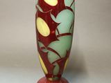 a red vase with a green and yellow design on it
