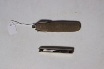 un petit couteau de poche et un couteau de poche encore plus petit posés sur une table