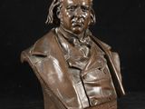 un buste en bronze représentant un homme en costume-cravate