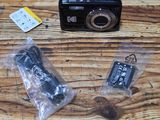 a small camera sitting on a wooden table next to other items