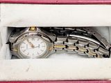 a watch that is in a pink box on the table