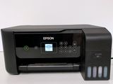 a black printer sitting on top of a table next to a white wall