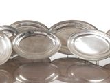 une grande quantité d'assiettes en argent empilées les unes sur les autres