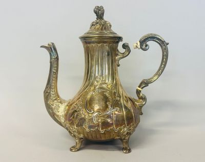 une théière en argent avec une anse sur une table