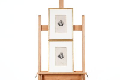 un chevalet en bois sur lequel sont posés deux tableaux