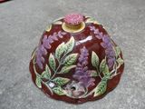 un bol rouge orné de fleurs et de feuilles violettes