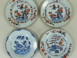 quatre assiettes ornées de motifs bleus et orange, posées sur une table