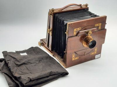 un vieil appareil photo avec un sac en tissu à côté