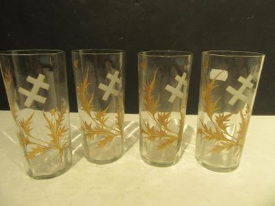 four glasses with crosses on them are lined up on a table