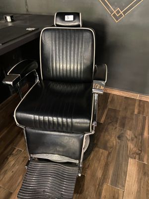 a black and white barber chair in a barber shop