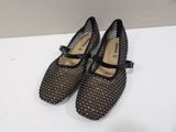 the shoes are black and white with black bows on them