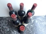 several bottles of wine are lined up on a counter top