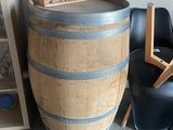 un tonneau de vin posé par terre à côté d'une chaise