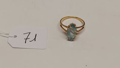 une bague en or sertie d'une pierre verte, avec une étiquette de prix