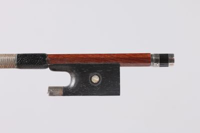 a close up of a violin bow on a white surface