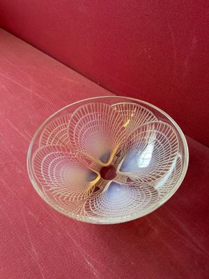 un bol en verre posé sur un canapé rouge, à même le sol