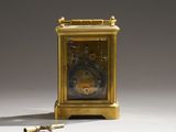 a small gold clock sitting on the floor next to a pair of screws